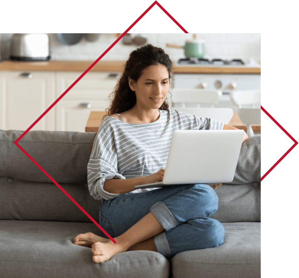 Woman sitting on couch using laptop.